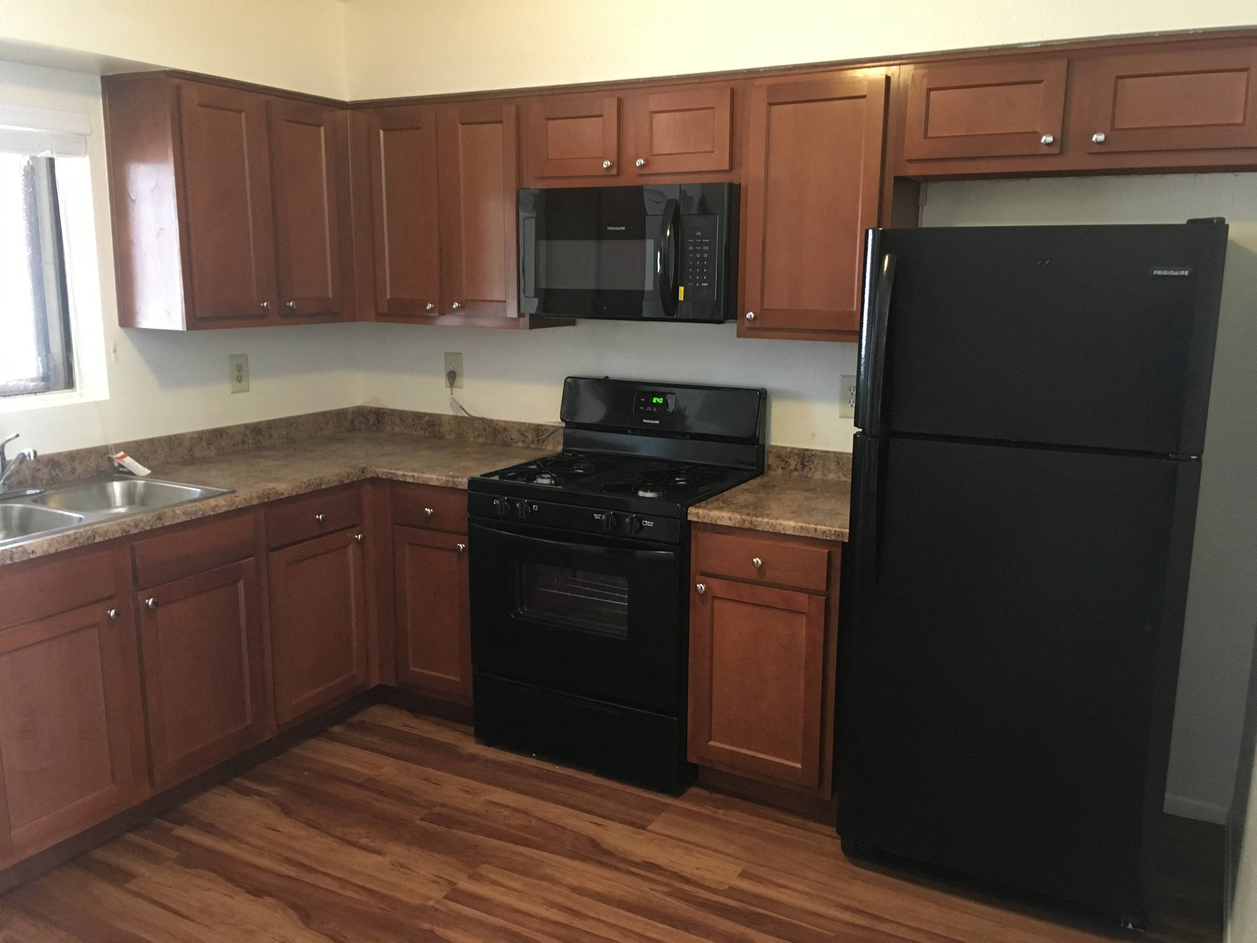 a kitchen with black appliances and wooden cabinets